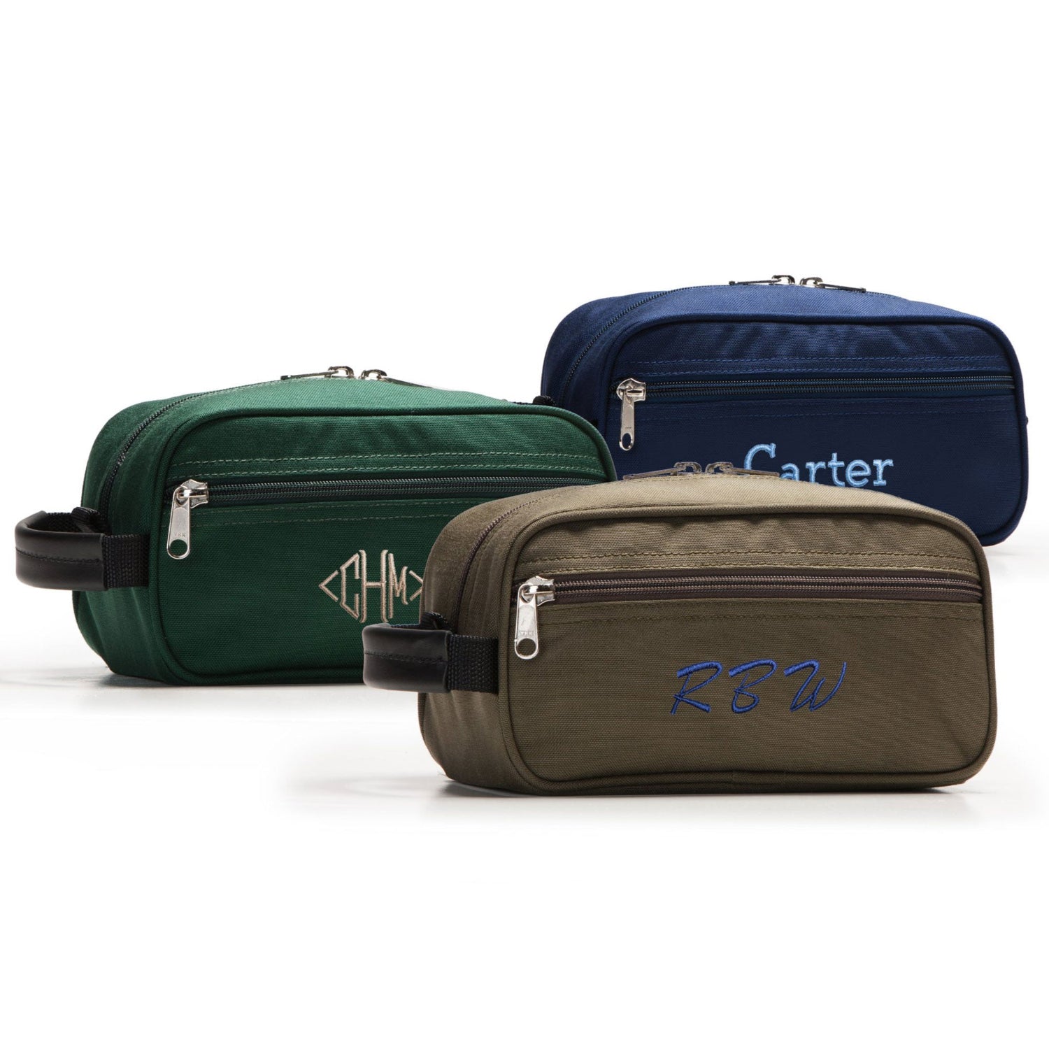Three toiletry bags in green, blue, and brown with embroidered initials on a white background