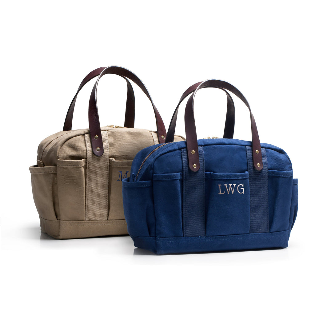 Two bags, one beige and one blue, with monogrammed initials on a white background.