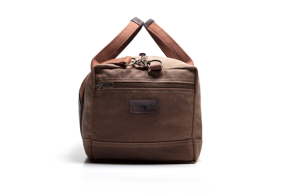 Brown duffel bag with leather handles on a white background