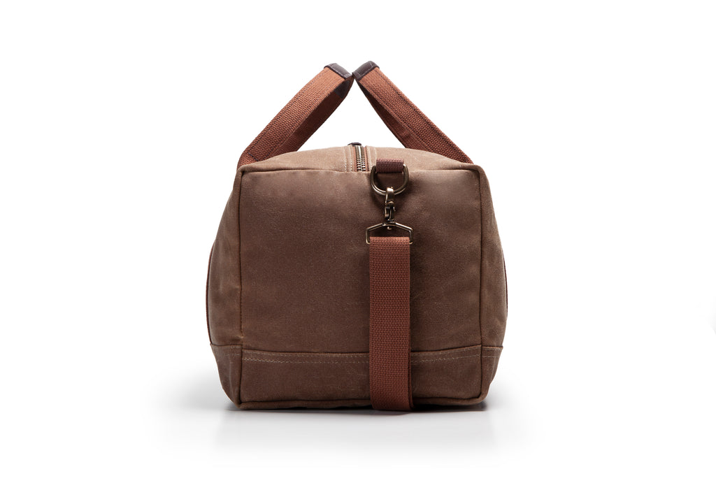 Brown duffel bag with brown straps on a white background