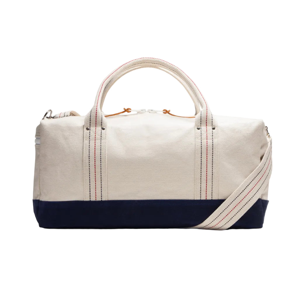 White duffel bag with navy base and red stitching on a white background