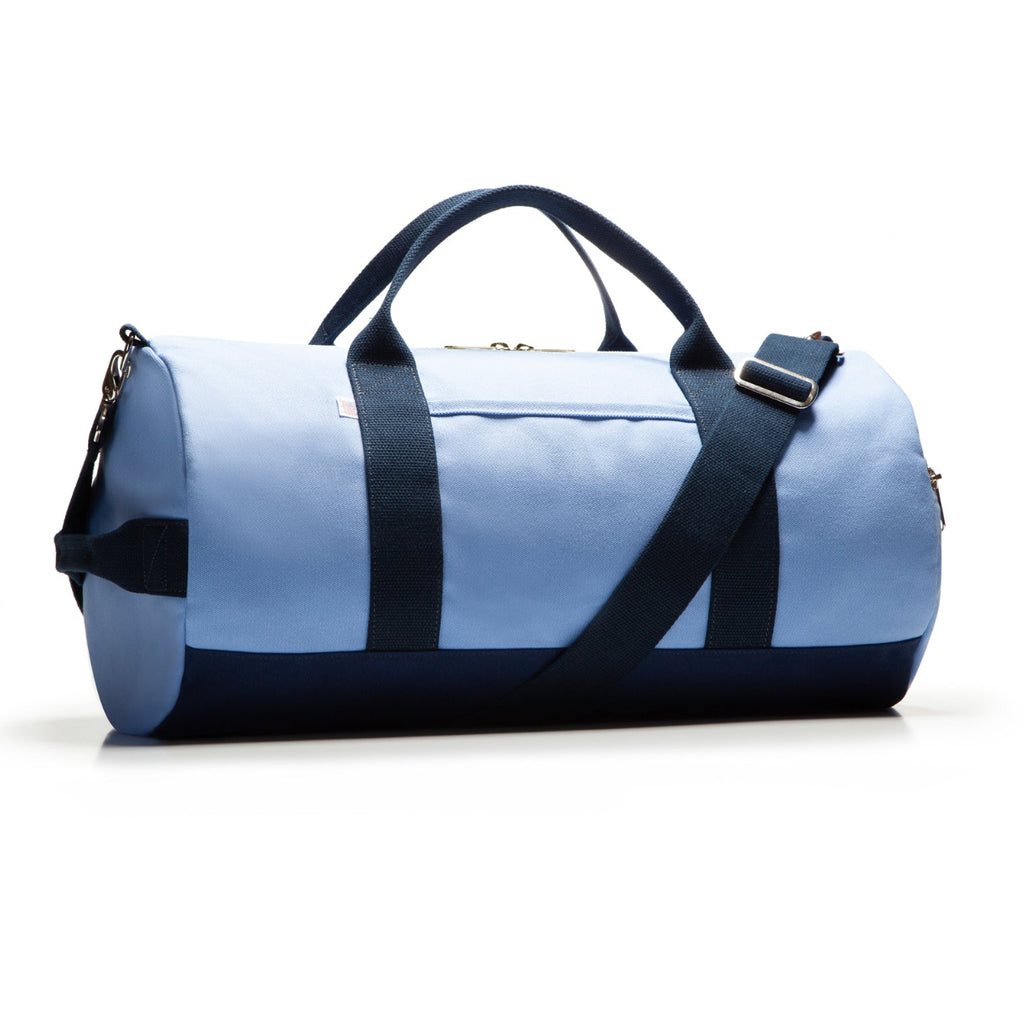 Blue duffel bag with black straps on a white background