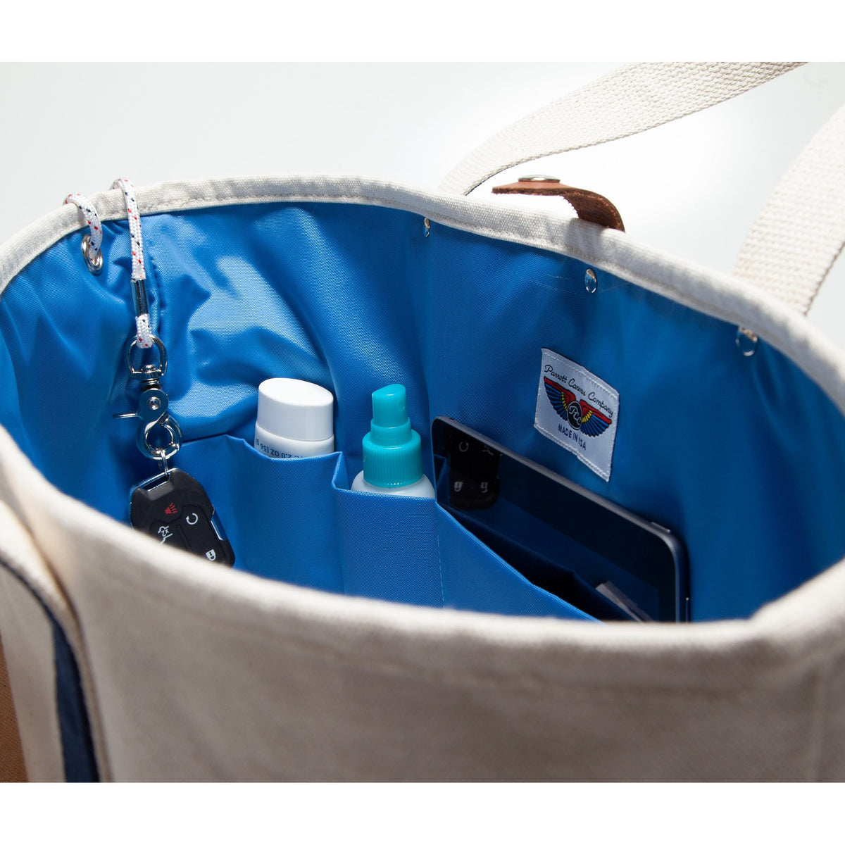 beige canvas tote bag, with inside nylon blue and pockets with leather straps