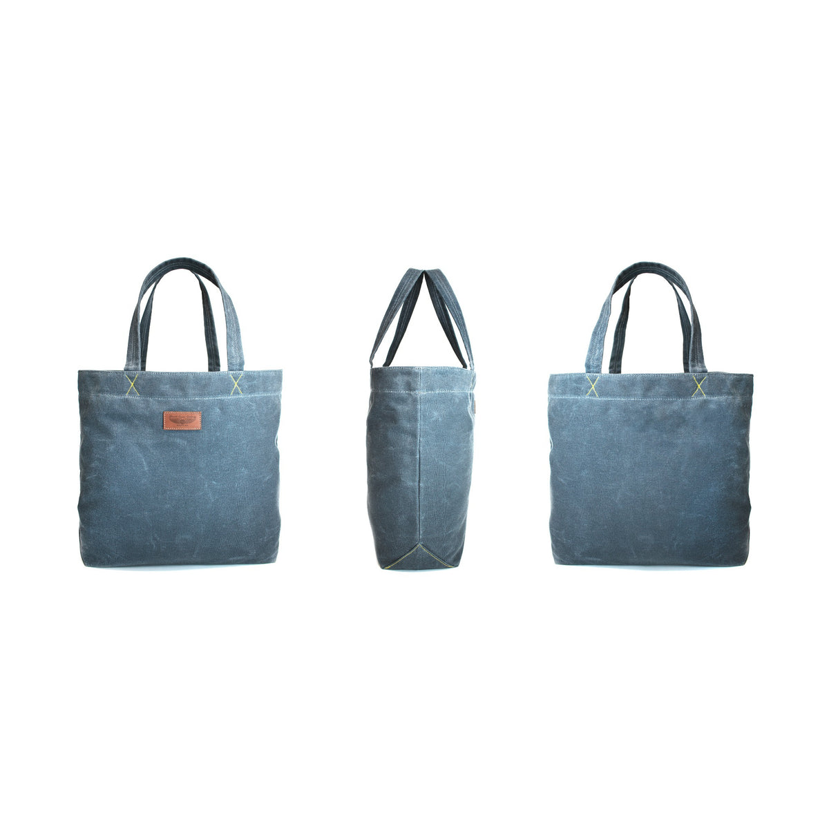 Three views of a blue canvas tote bag on a plain white background, showing the front, side, and back perspectives.