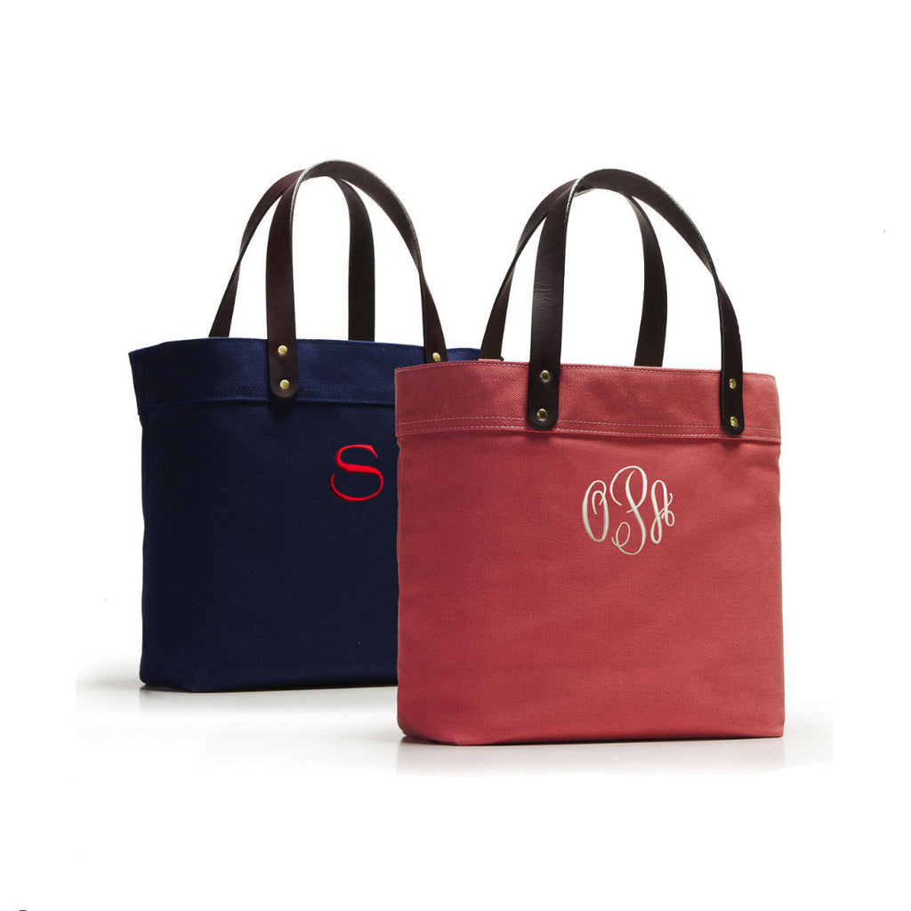 Two tote bags, one navy and one red, with monogram initials on a white background.