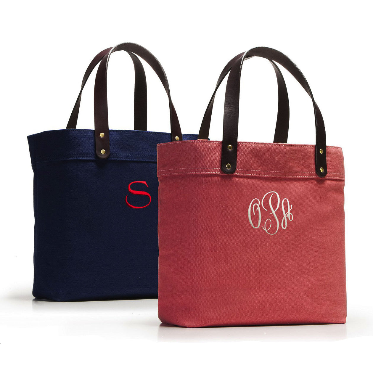 Two tote bags, one navy and one red, with monogram initials on a white background.