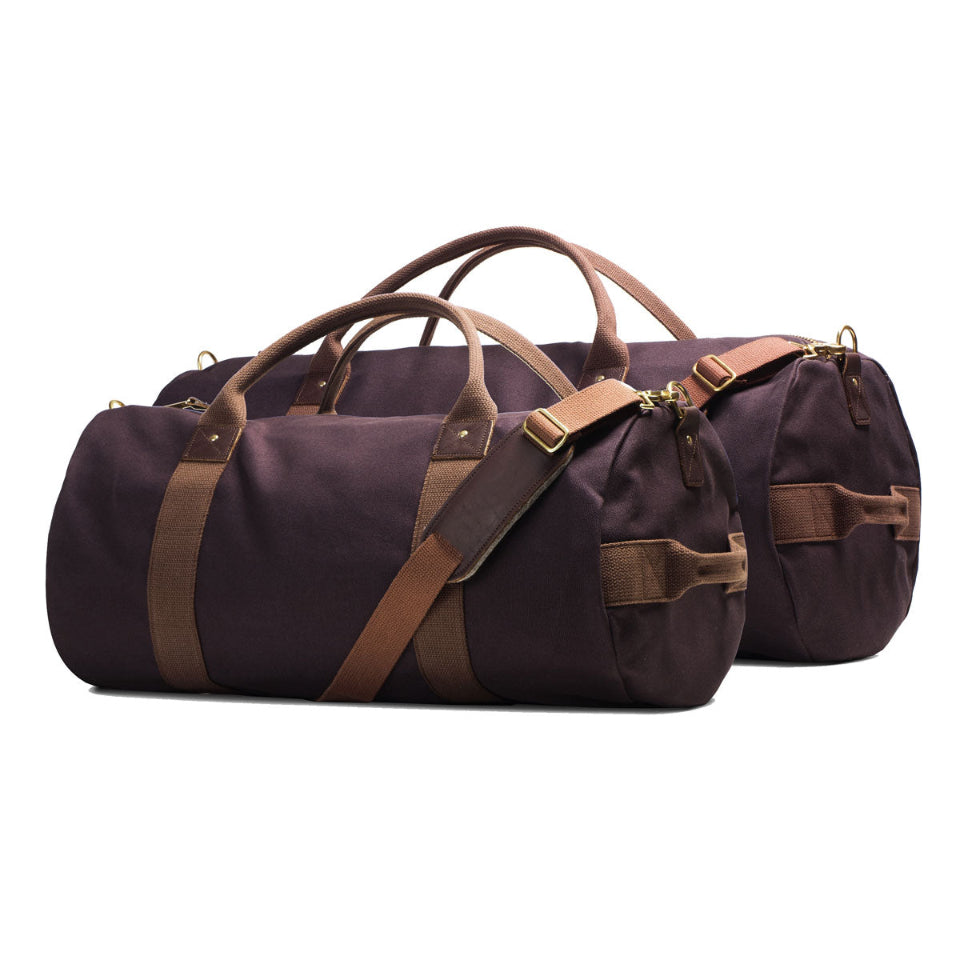 Brown duffel bag with leather straps on a white background