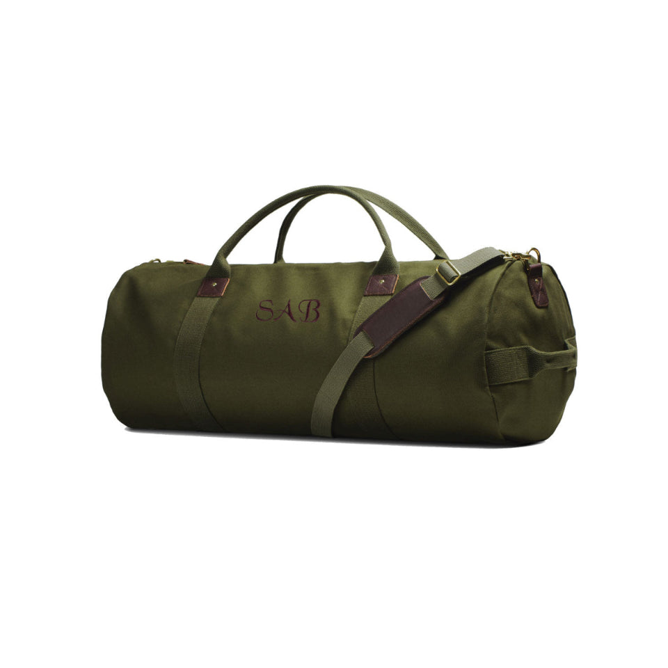 Green duffel bag with brown straps on a white background