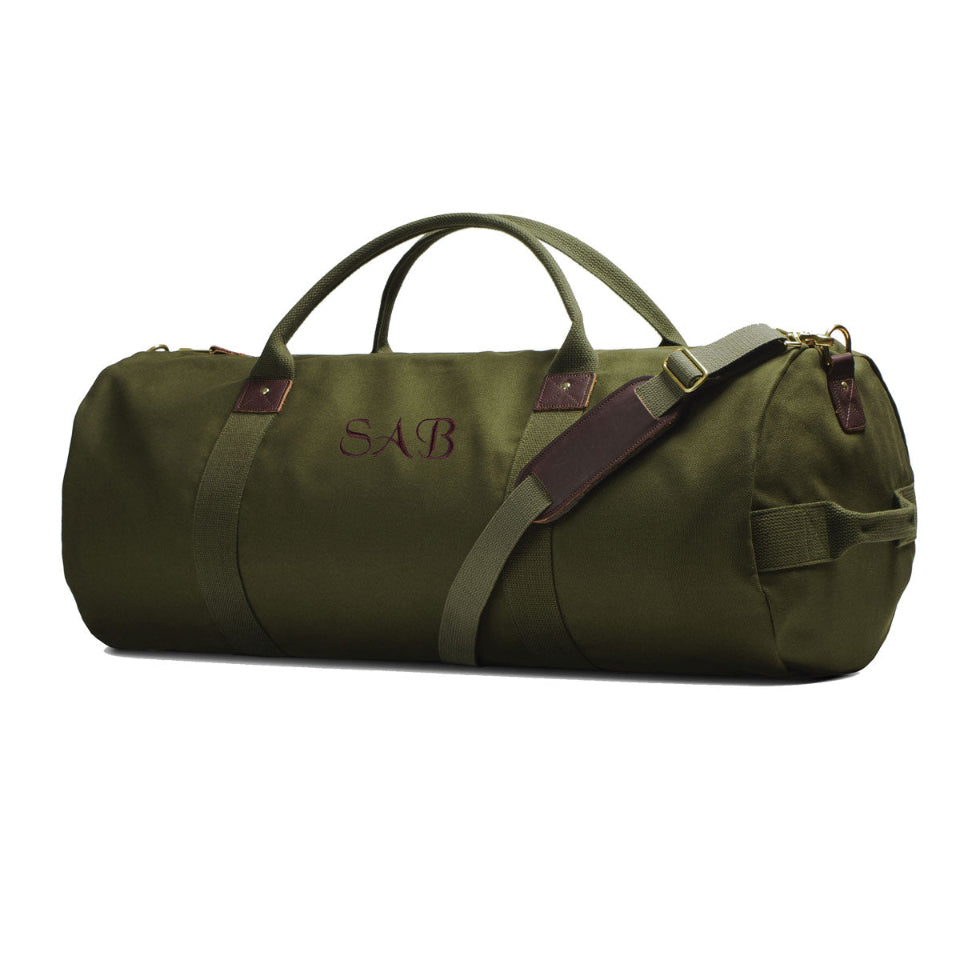 Green duffel bag with brown straps on a white background