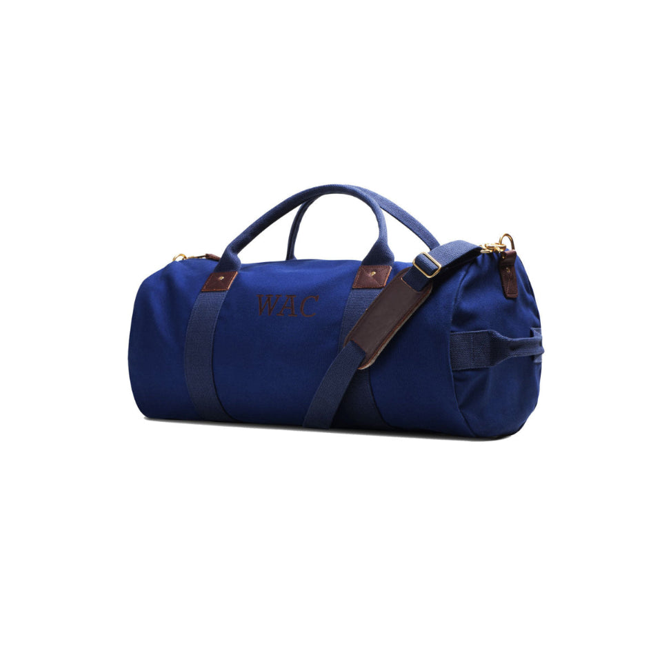 Blue duffel bag with brown straps on a white background