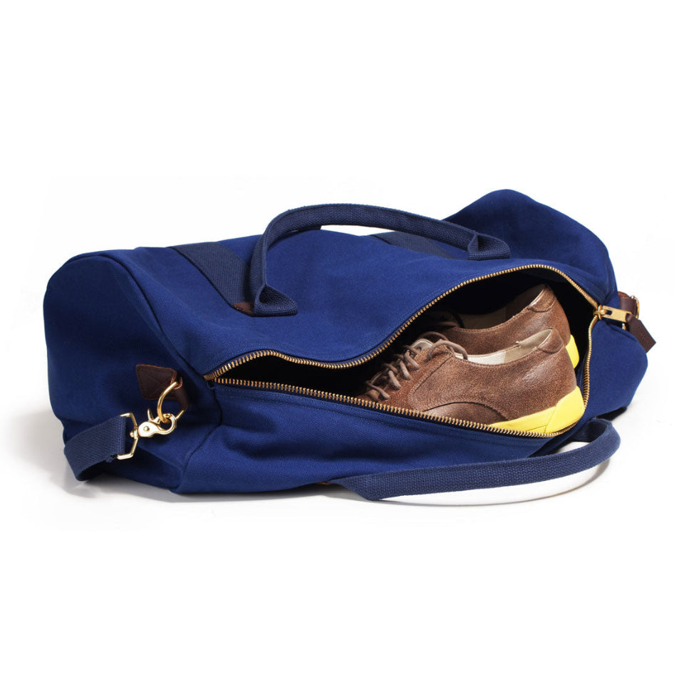 Blue duffel bag with a brown shoe inside on a white background