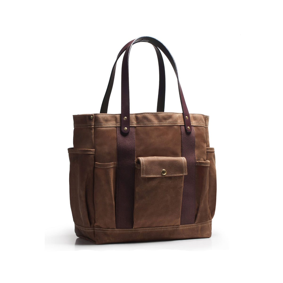 Brown wax duck canvas tote bag with brass hardware and brown leather straps multiple pockets on a white background