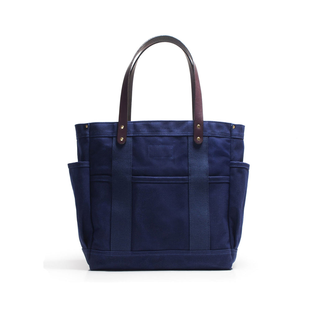 Blue tote bag with brown handles on a white background