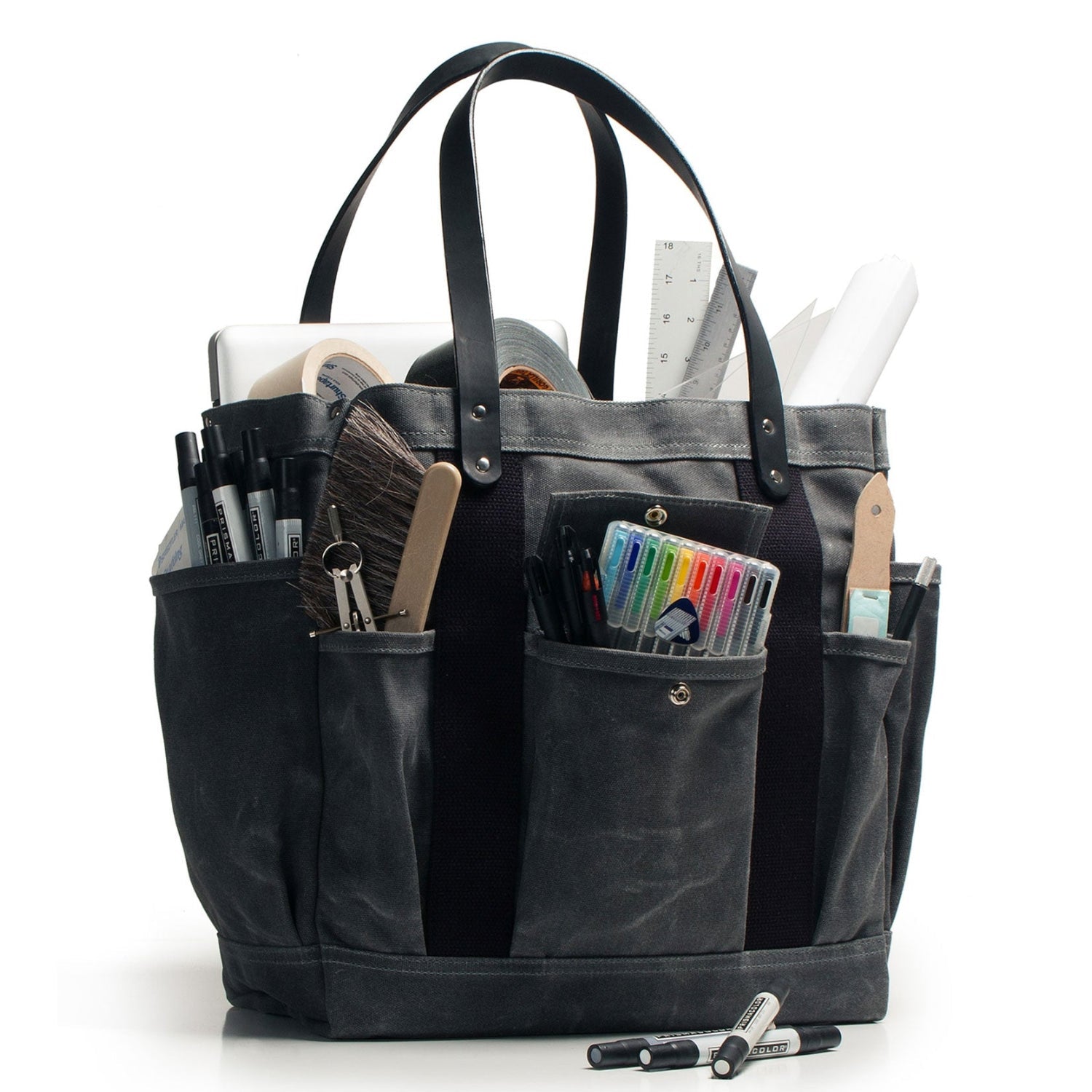 Black tote bag with various stationery items on a white background