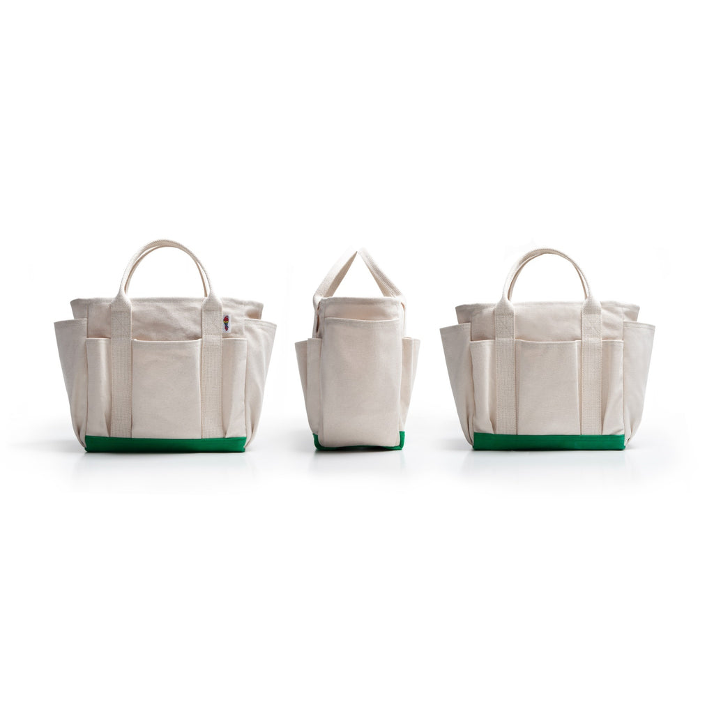 Three canvas tote bags in different sizes arranged side by side on a white background. The bags are off-white with a green base and top handle trim.